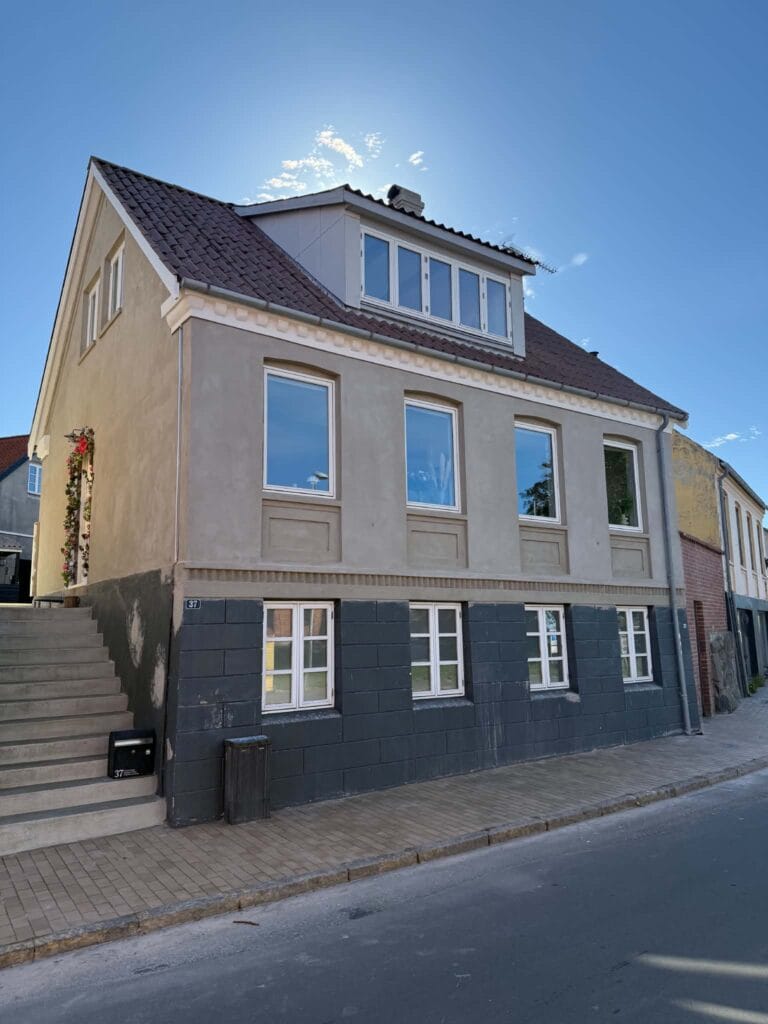Murer job hos NP Murermester: færdig netpudset facade med lys puds og mørk sokkel